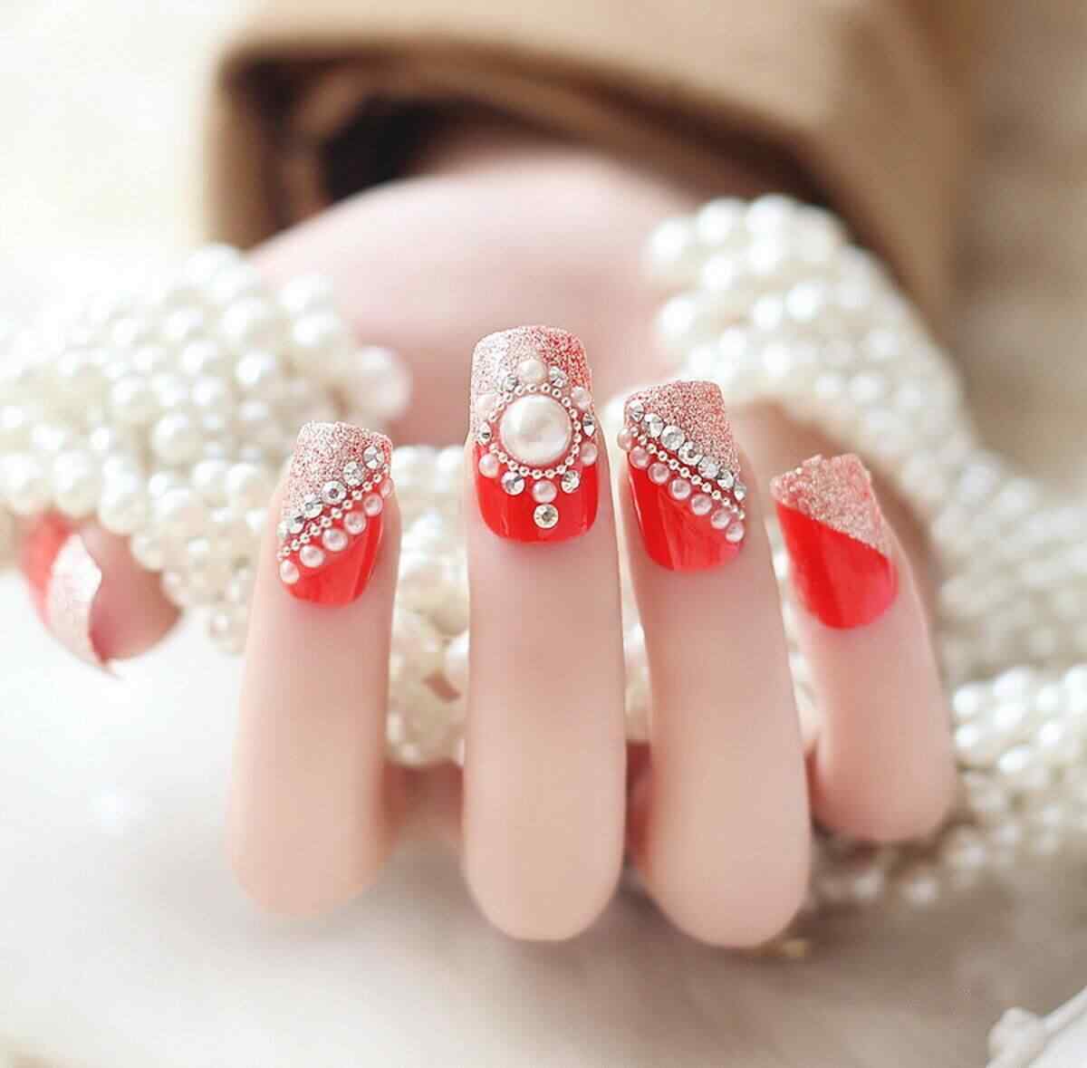 Este diseño de uñas con piedras y base roja me encanta