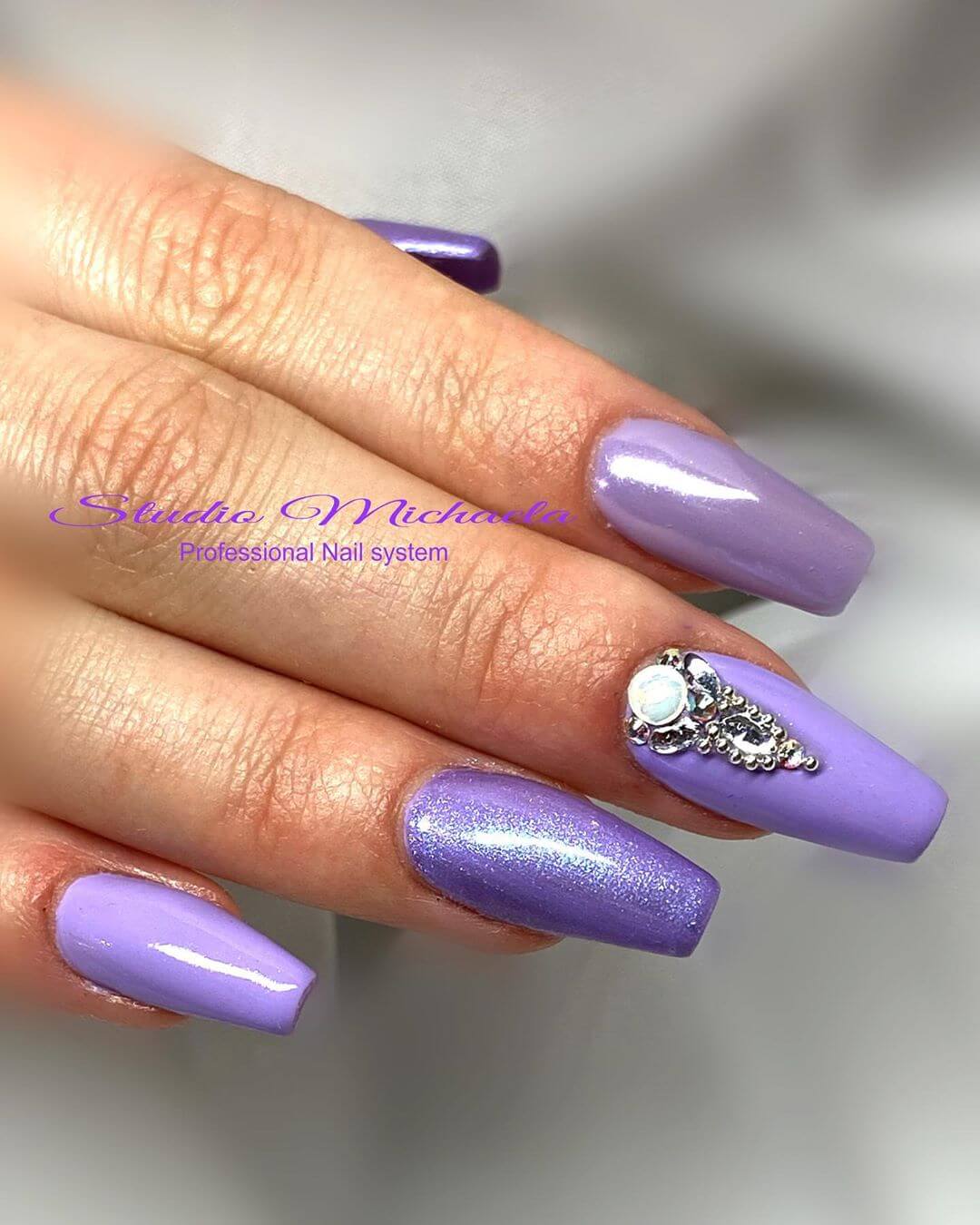 decoración de uñas violeta con piedras