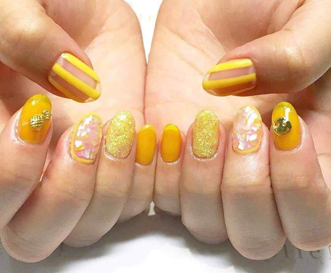 diseño de uñas amarillas con glitter