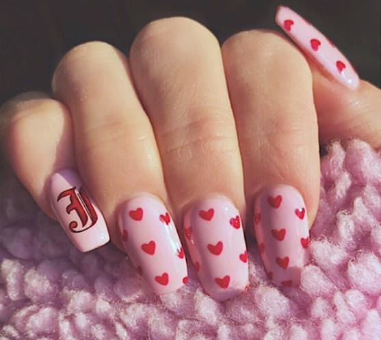 diseño de uñas rosa de san valentín con corazones rojos