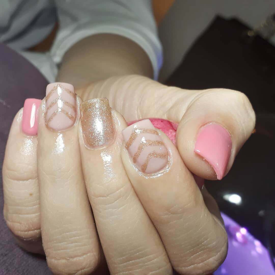 diseño de uñas doradas con rosa