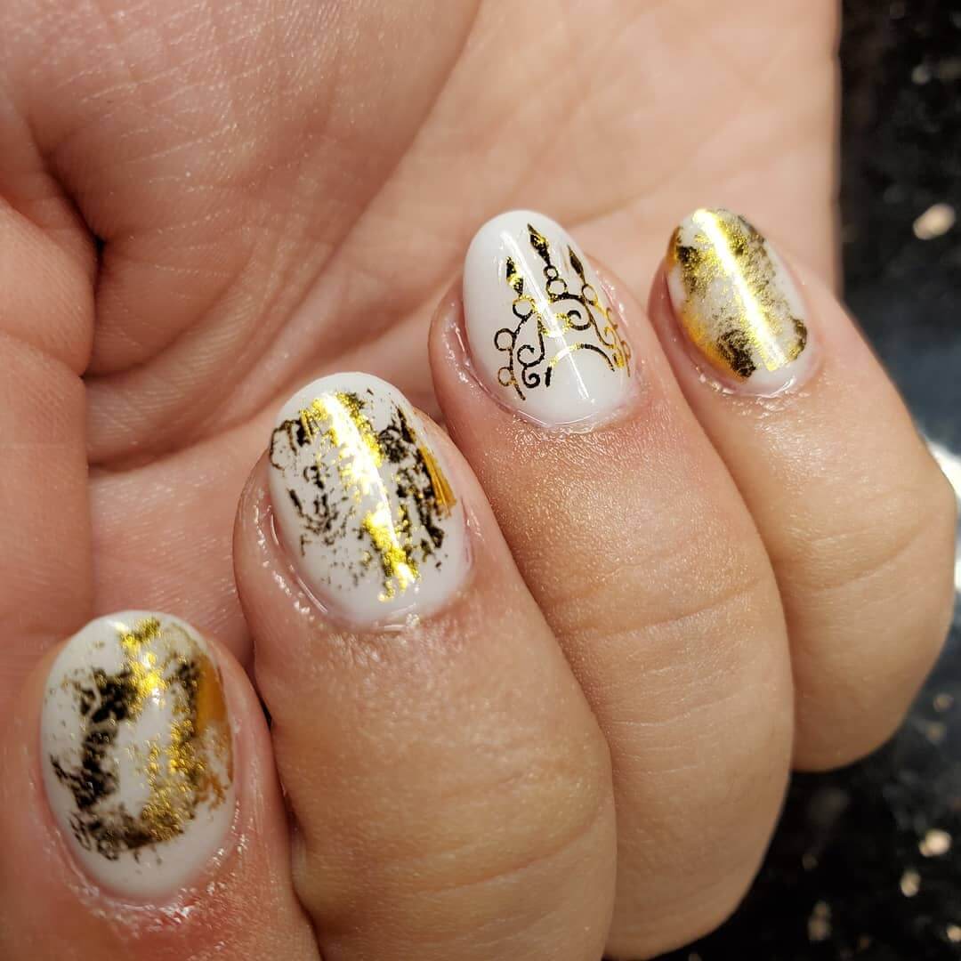 uñas blancas con estampado dorado