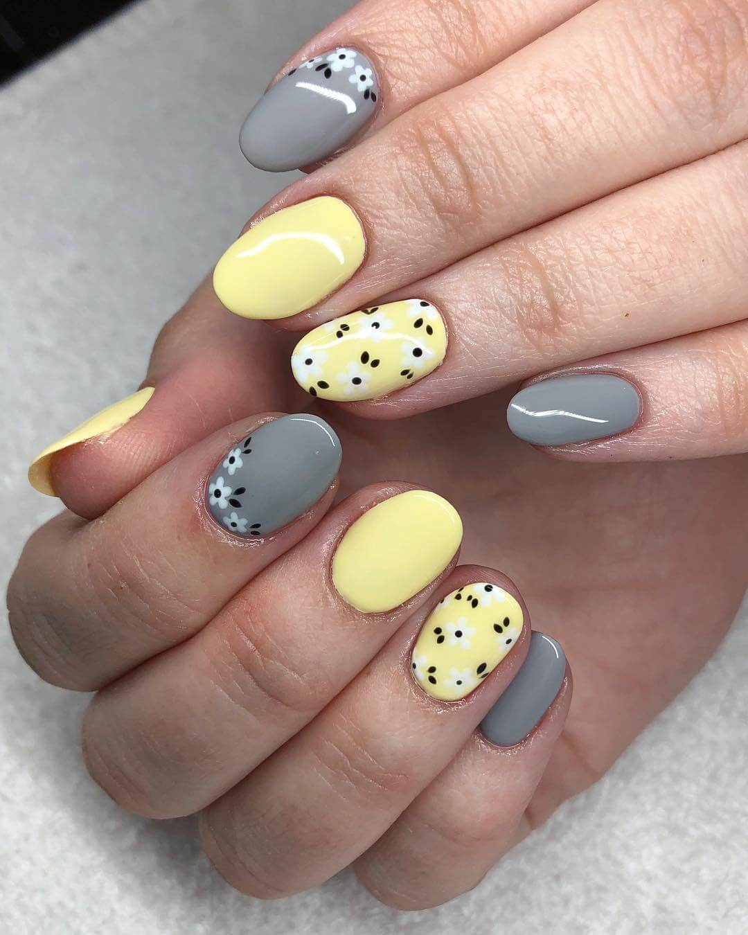 uñas grises y amarillas con flores